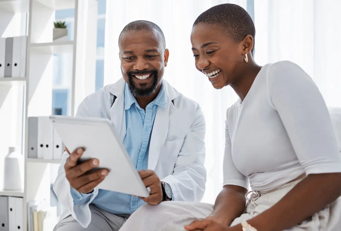 EDUCATE & GROW YOUR PATIENT BASE; Summus doctor shows his patient the screen of his digital tablet; both are smiling and laughing