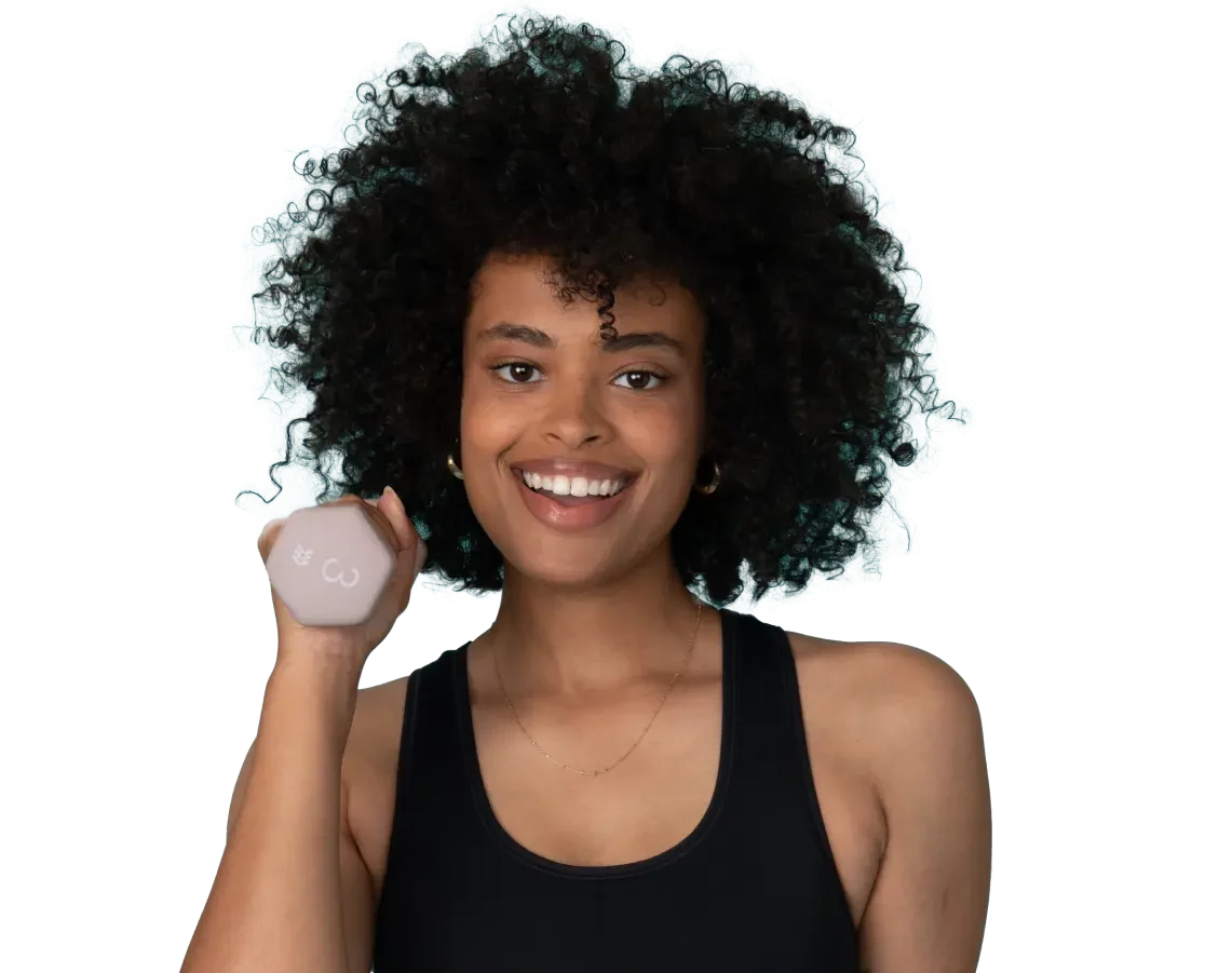 African-American woman with curly hair wearing athletic sportswear smiling at the camera and holding a 3 pound dumbbell
